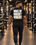 Isaiah wearing the black Wake Up Worship Workout tee in the gym, showing the white and gold back graphic